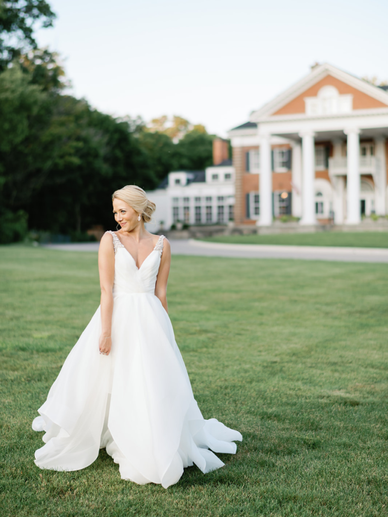 Bride posing in front of Langdon Hall at golden hour