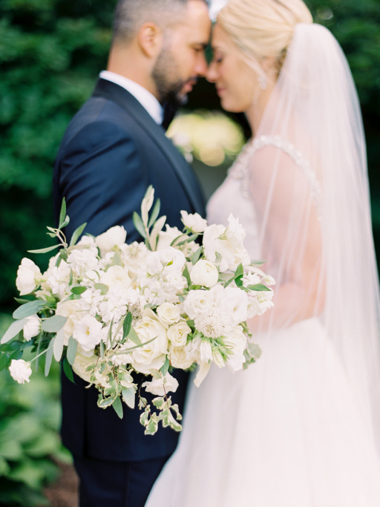 White bridal bouquet filled with lush florals and greenery