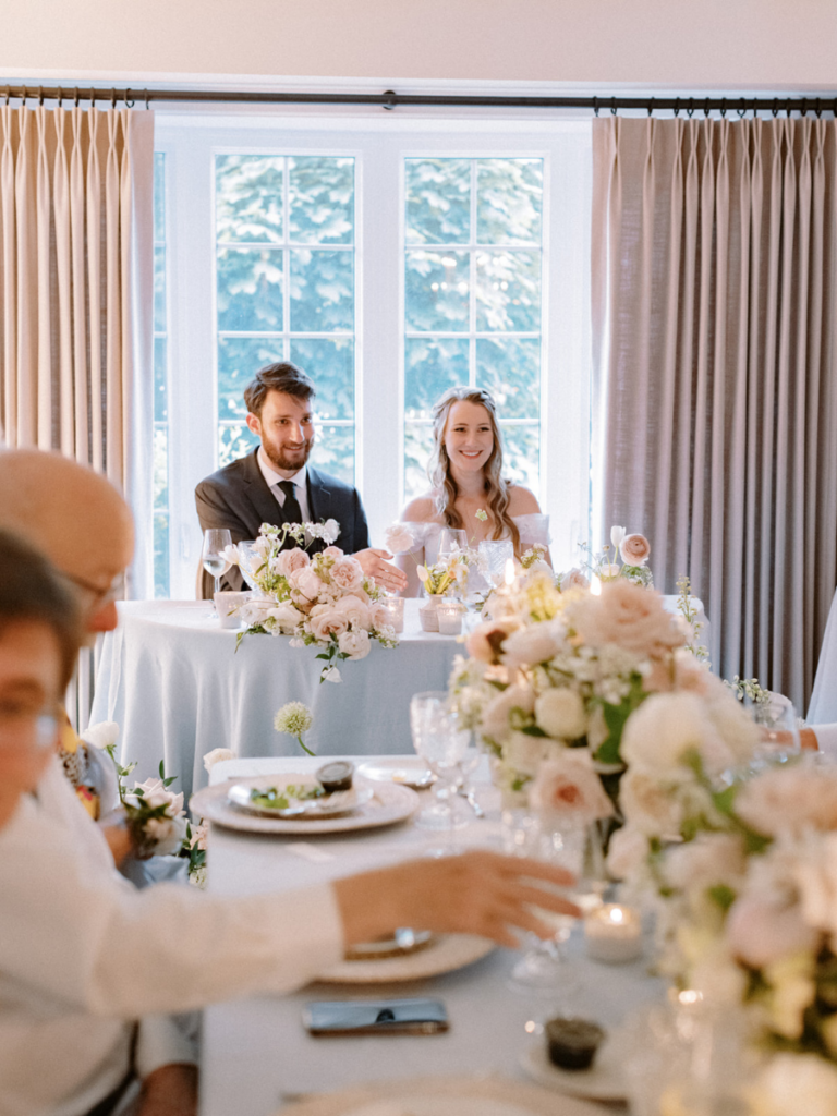 Couple smiling overlooking their guests at their intimate wedding reception