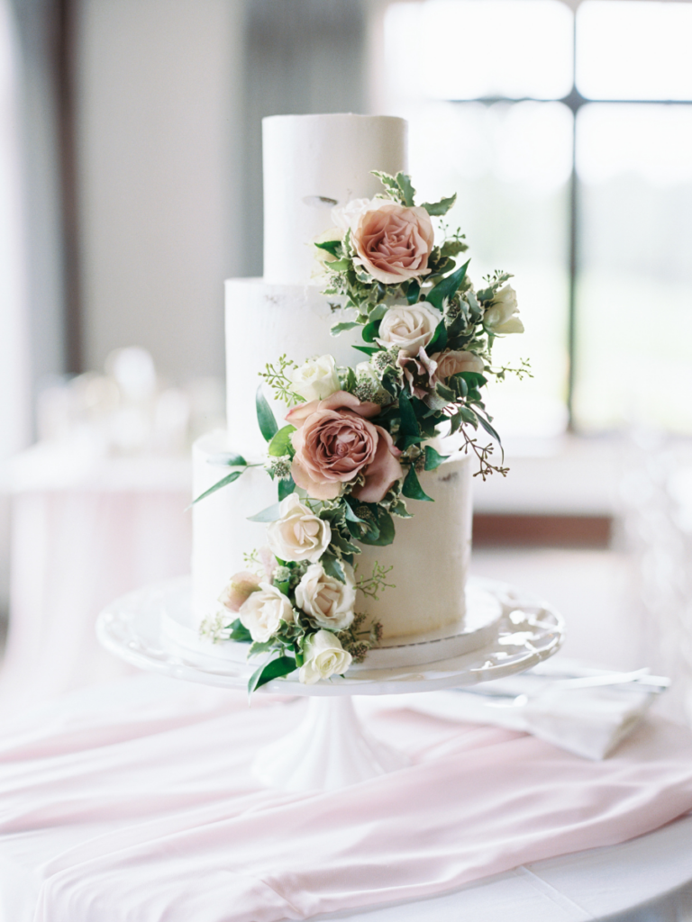 3-tier white wedding cake with trailing flowers down the front