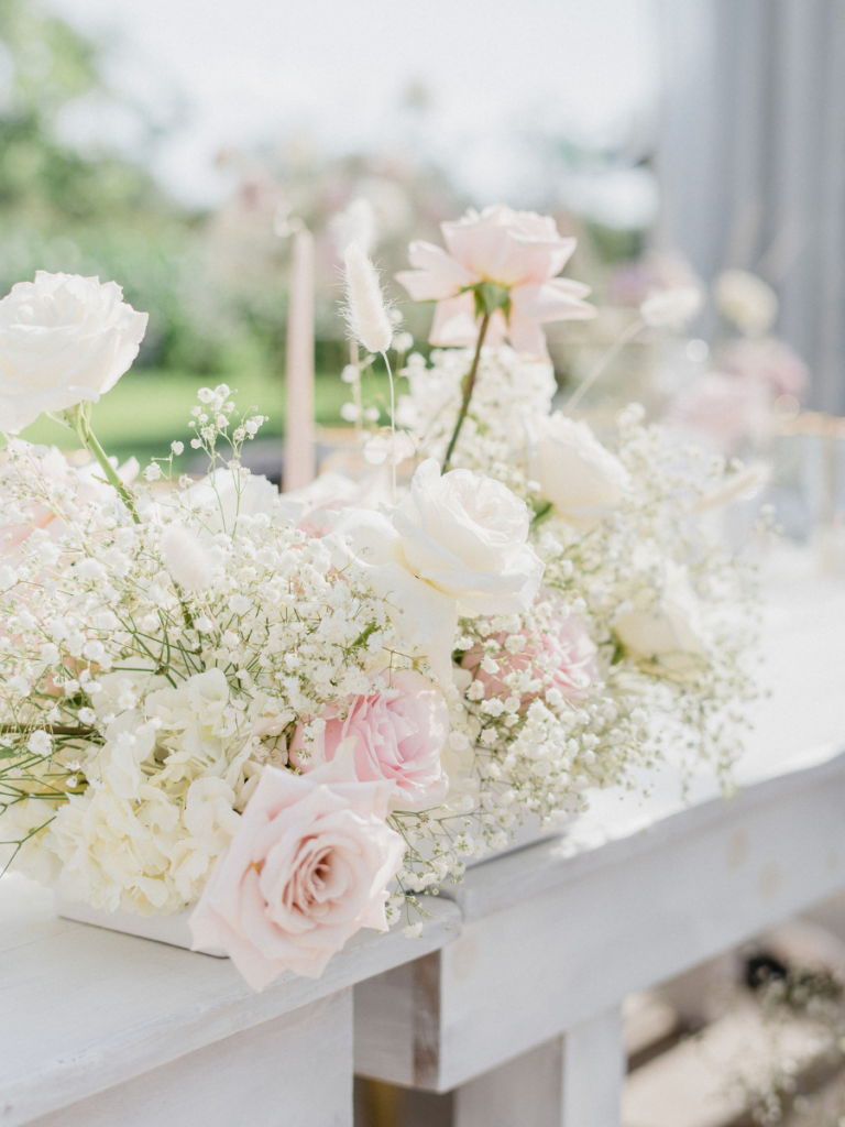 Modern floral centerpiece with blush and white roses and a cloud of baby's breath
