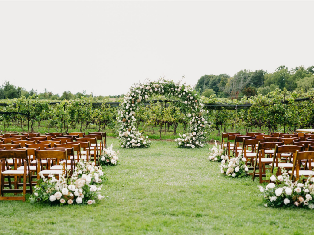 Floral arrangements lining the sides of the aisle at Calamus Estates winery outdoor ceremony space