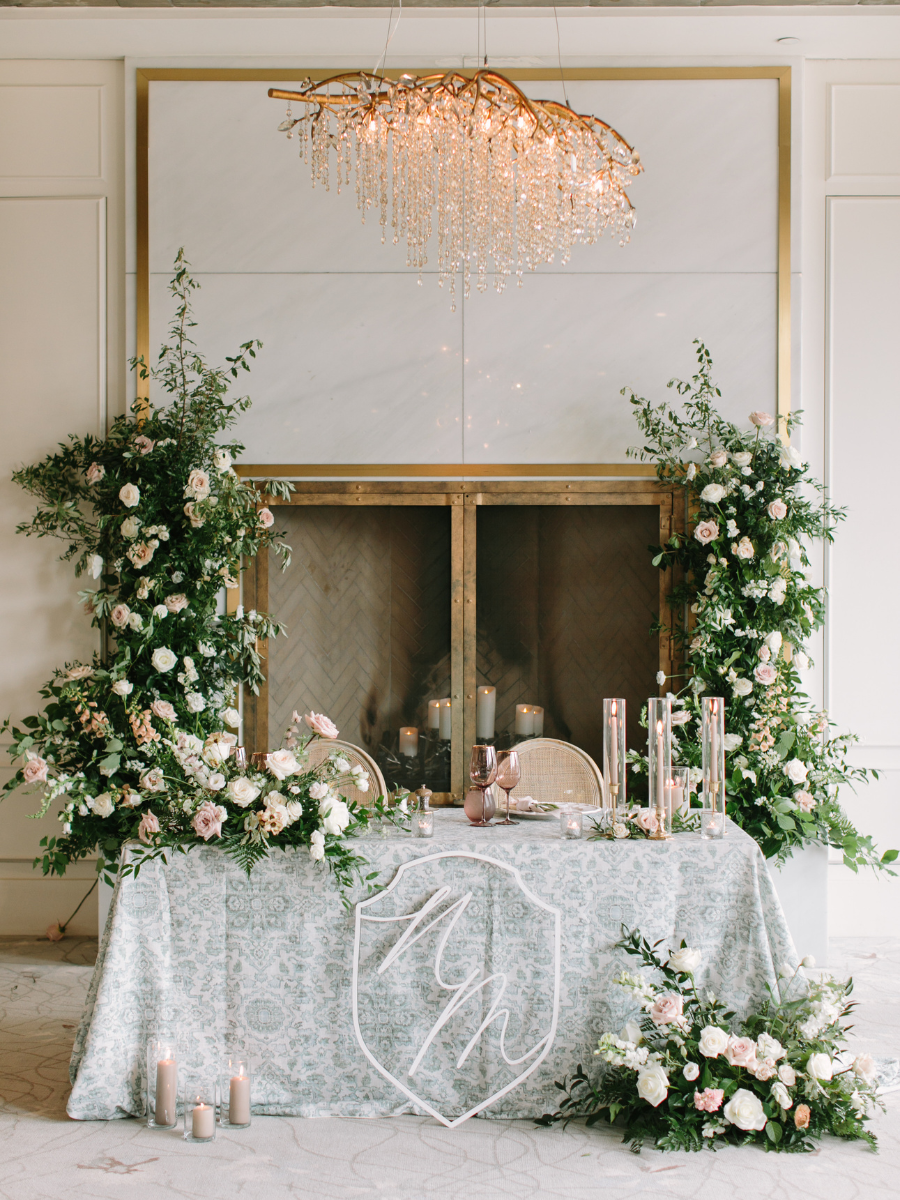 Flower towers behind sweetheart table with candles and lots of florals