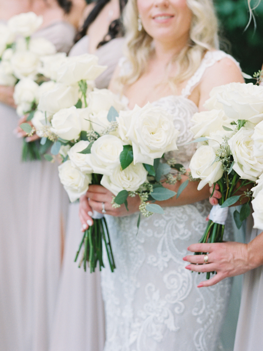 Modern bridal bouquet with white long stem roses and seeded eucalyptus 