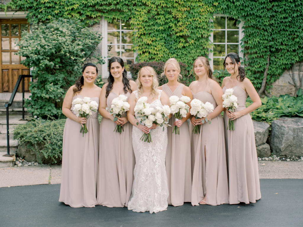 Bride and her bridesmaids standing outside at Ancaster Mill