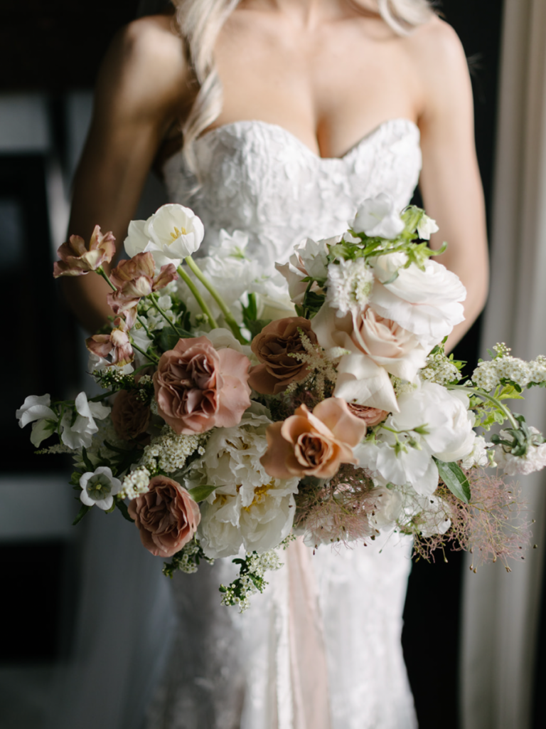 Close up of the bridal bouquet with all the spring blooms, tulips, roses, ranunculus, peonies and smoke bush
