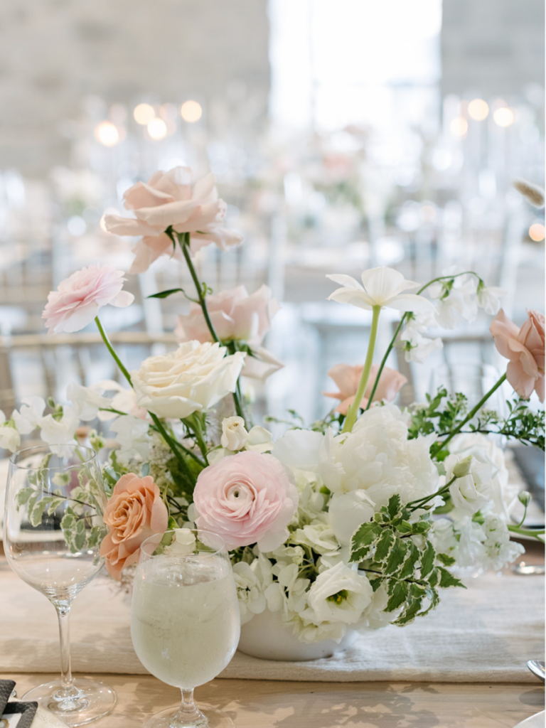 Blush and white spring floral arrangement with roses, tulips, peonies, and ranunculus