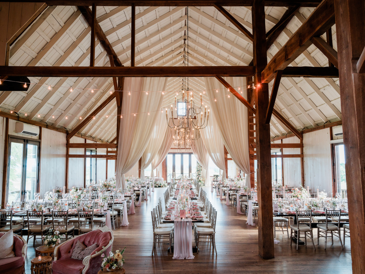 Earth to Table: The Farm reception space The barn all fully decorated with draping, florals, candles and place settings.