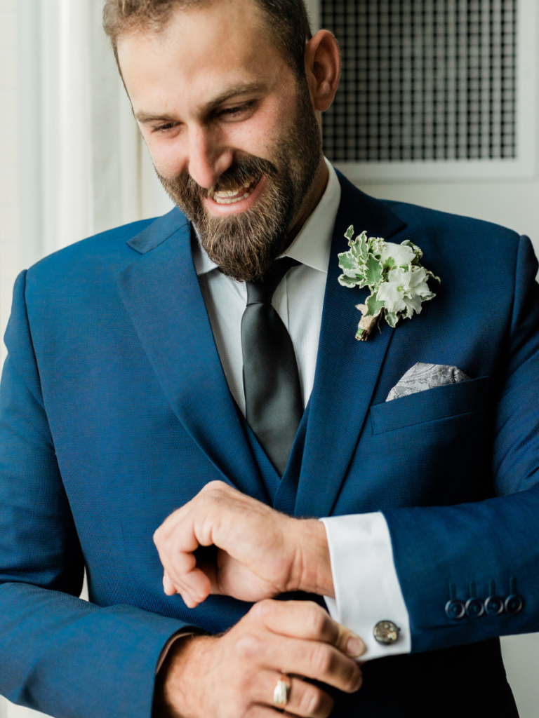Groom doing up his cufflinks on his wedding day