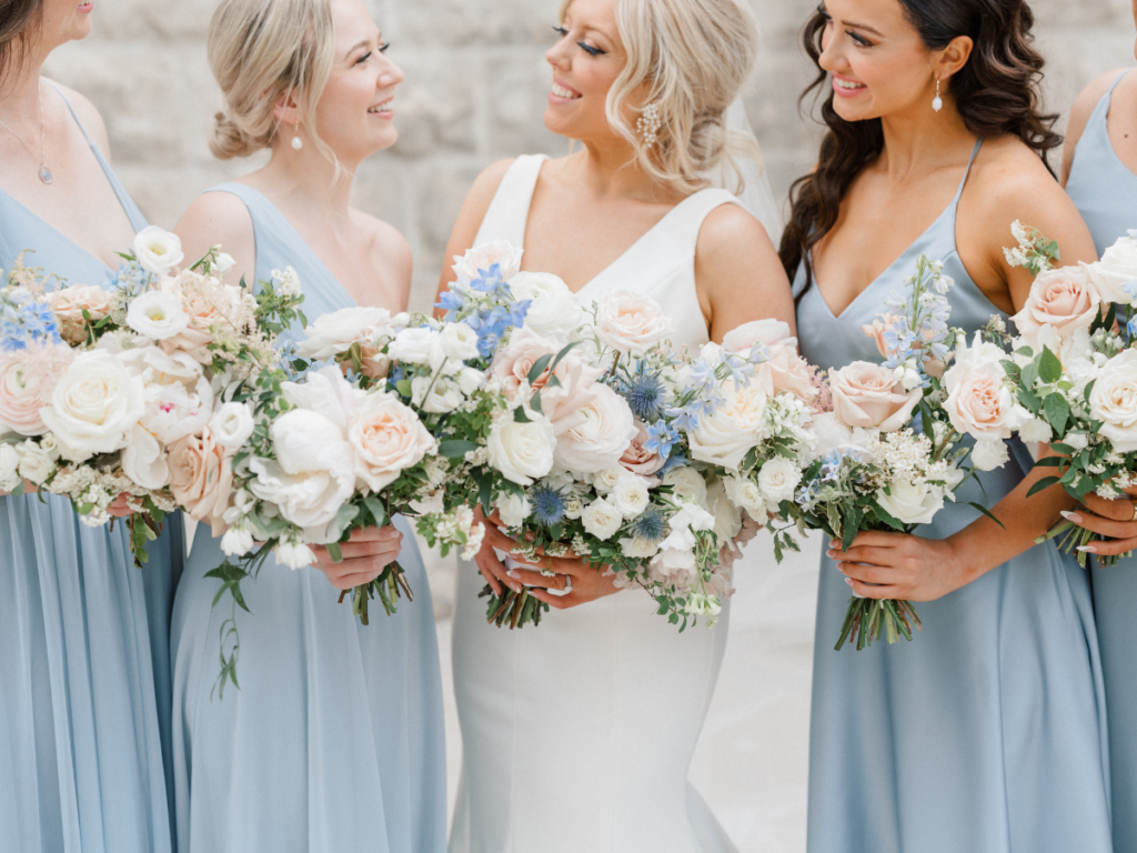 Close up of bouquets filled with blush and white with a accent of blue flowers