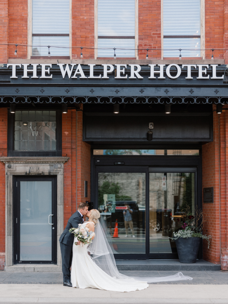Bride and groom kissing in front of The Walper Hotel