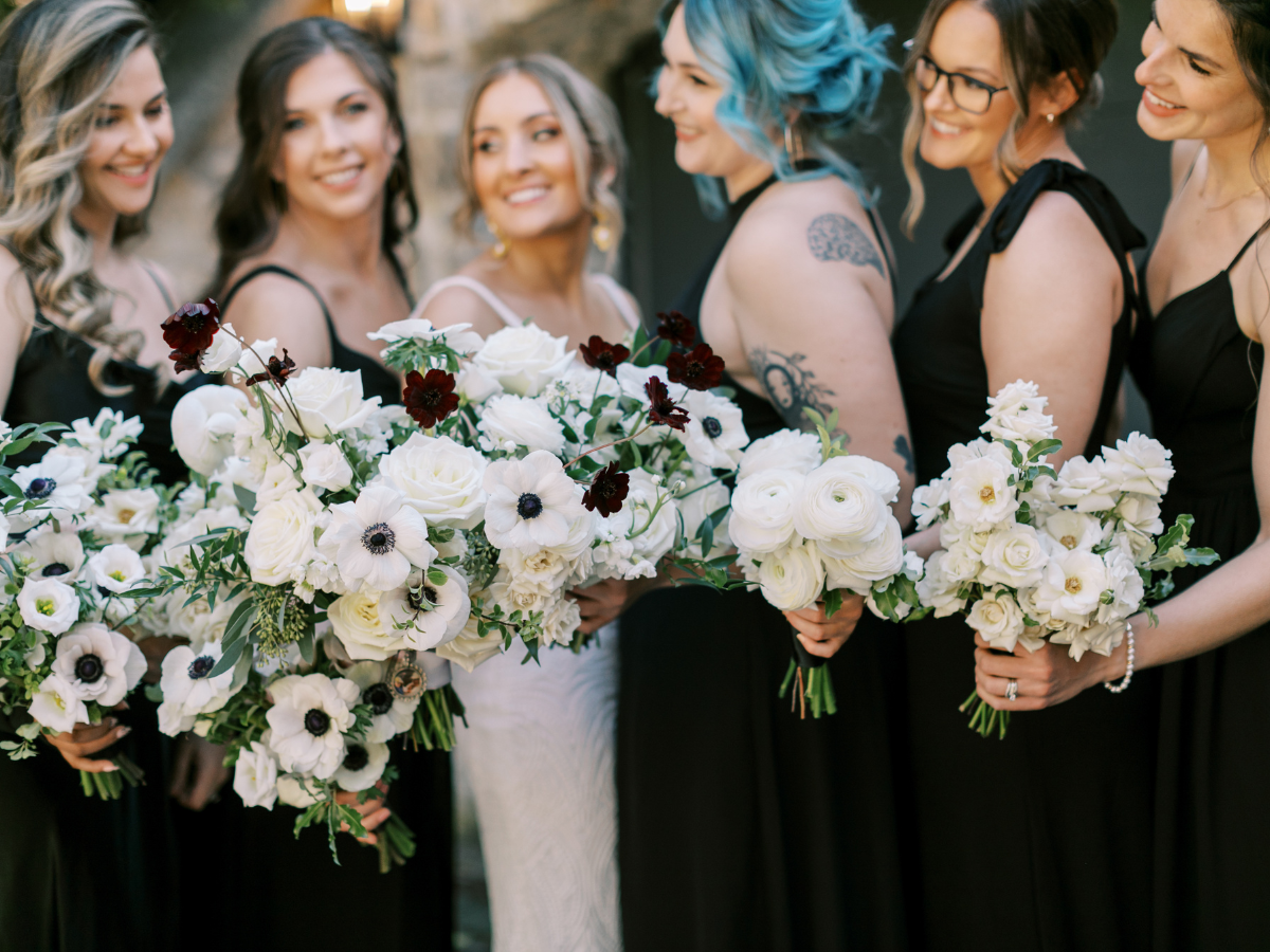 Bride and her bridesmaids holding their bouquets. Bridesmaids holding monochromatic bouquets