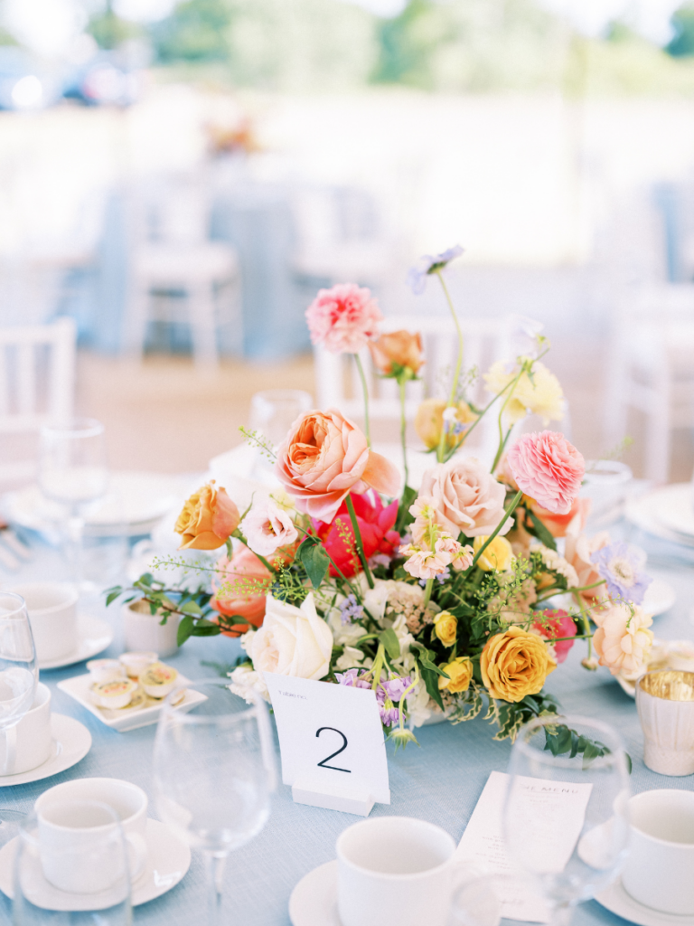 Colourful flower centrepiece on table with blue linen